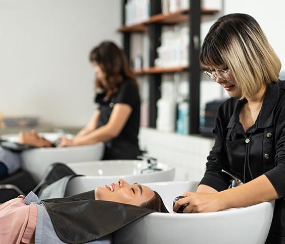 Decorative image - salon assistant washing clients hair in salon