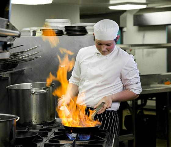 Decorative image - Student cooking in kitchen