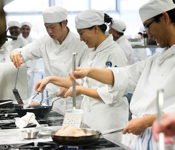 Decorative Image - Students cooking in kitchen