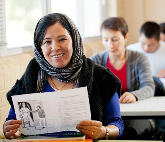 Woman holding up English language learning materials
